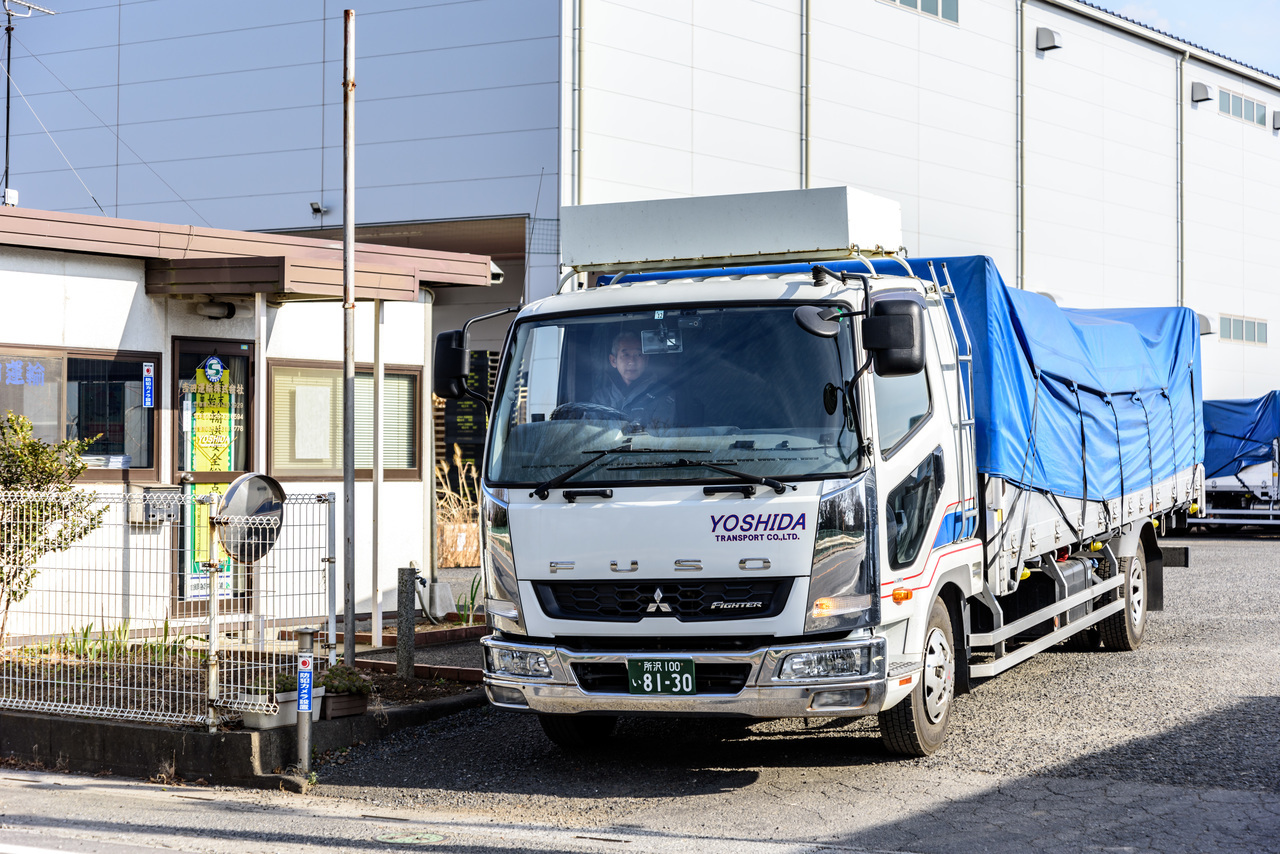 車庫を出発するトラックの写真